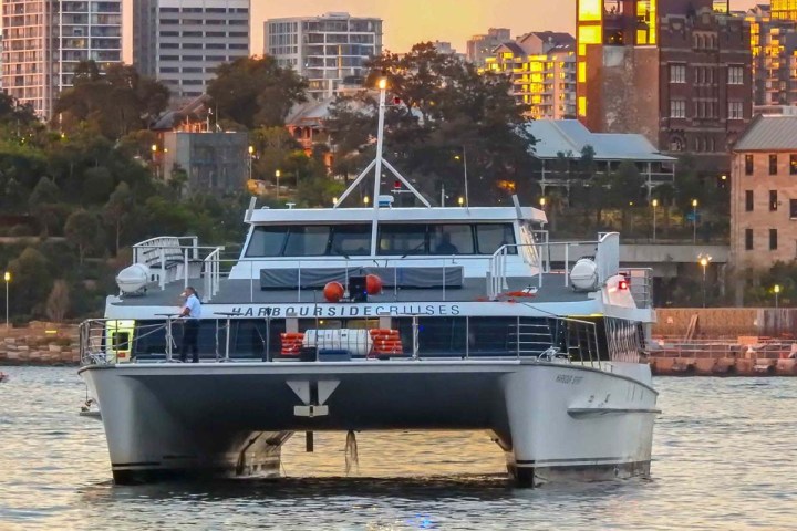 a small boat in a body of water with a city in the background