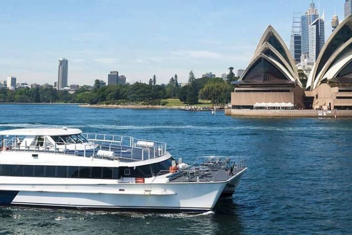 a large ship in a body of water with a city in the background