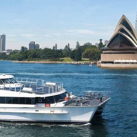 a large ship in a body of water with a city in the background