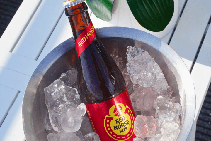 Bottle of Red Horse Beer in an ice-filled bowl on a white table.