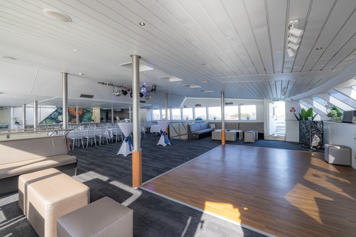 Spacious indoor venue with seating, large windows, and a wooden dance floor.