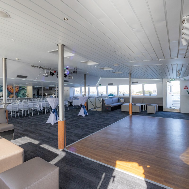 Spacious indoor venue with seating, large windows, and a wooden dance floor.